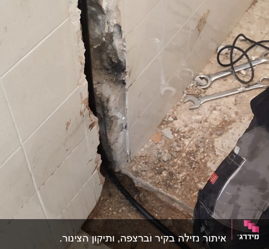 קיר פתוח עם צינור וכלי עבודה של אינסטלטור